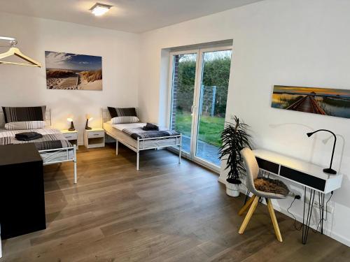 - un salon avec un lit et un bureau dans l'établissement Ferienhaus am Glück, à Bad Zwischenahn