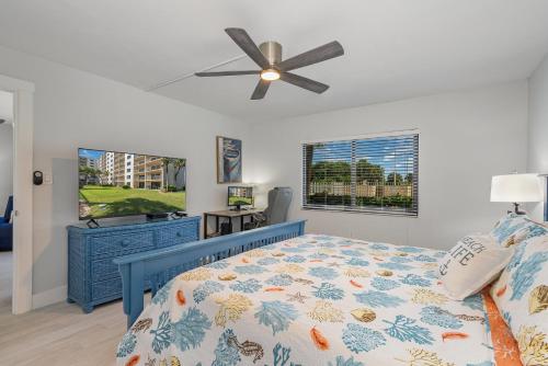 a bedroom with a blue bed and a ceiling fan at Canaveral Towers Resort-Beach, Surf, Rocket Launches in Cape Canaveral