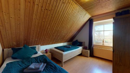 een kleine kamer met 2 bedden en een raam bij Ferienhaus Zur Mühle Mitling-Mark in Westoverledingen