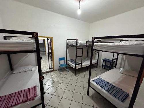 a room with four bunk beds in a room with a mirror at Hostal Zipolite Arteaga in Oaxaca City