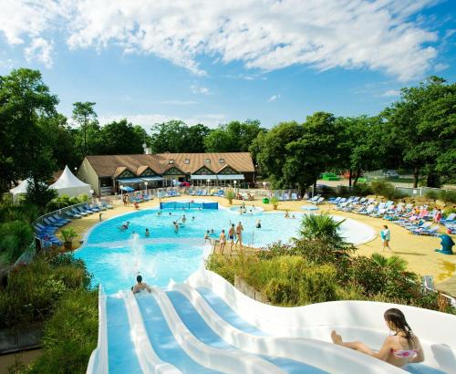 un groupe de personnes dans une piscine d'un complexe hôtelier dans l'établissement Mobil home tout confort 3 chambres camping Les Pierres Couchées, à Saint-Brévin-les-Pins