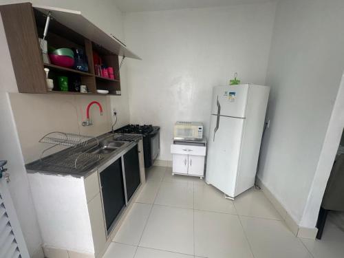 eine Küche mit einem weißen Kühlschrank und einem Herd in der Unterkunft Casa - Temporada Cuiabá MT in Cuiabá
