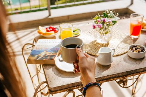 una persona sentada en una mesa con una taza de café en BENS L'Hôtel Palermo en Buenos Aires