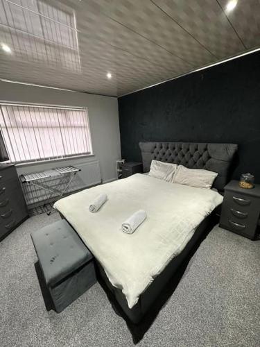 een slaapkamer met een groot bed met twee telefoons erop bij Charming Heywood retreat house in Heywood