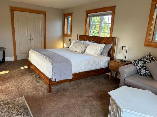 a bedroom with a bed and a couch at Tides Inn Guest Suites in Halls Harbour