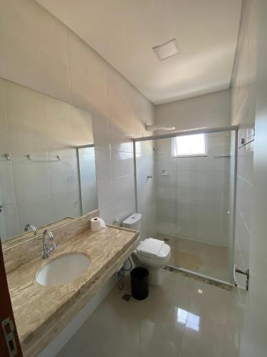 a bathroom with a sink and a toilet and a shower at Flats Grangeiro in Crato