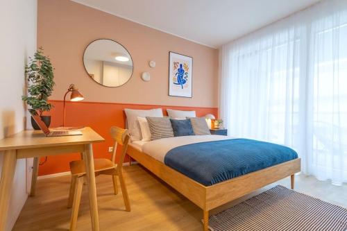 a bedroom with a bed and a desk and a mirror at Design apartment • Balcony • Free Parking • Yoga • 10 mins to center in Prague