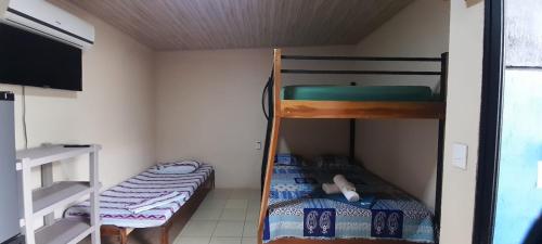 a bunk bed room with two bunk beds and a flat screen tv at Cabinas Rubik 1 in Savegre