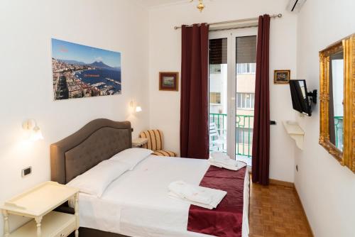 a small bedroom with a bed and a balcony at Suite Cervantes in Naples