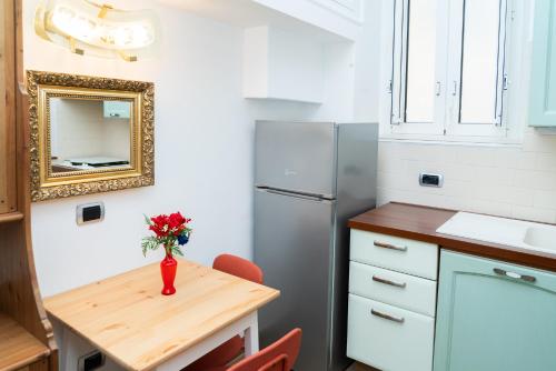a small kitchen with a table and a refrigerator at Suite Cervantes in Naples