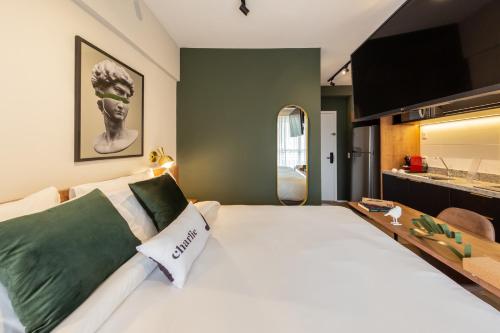 a bedroom with a large white bed and a mirror at Charlie Panorama Butantã in Sao Paulo