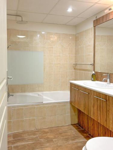 une salle de bain avec une baignoire et un lavabo dans l'établissement Charmante maison climatisée, 2ch, à Callian