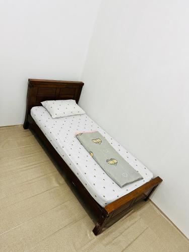 a small bed in a corner of a room at Room for single person with sharing washroom in Sharjah