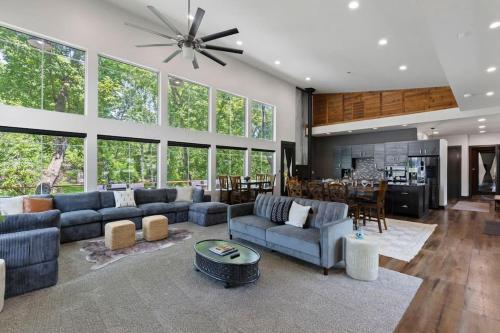 モンゴメリーにあるLUX Treehouse on Private Lake next to Lake Conroe with Game room, Paddleboards, Lake Views, and more!の青いソファとキッチンのあるリビングルーム