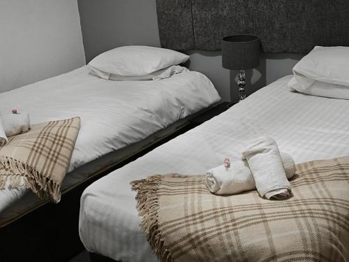 two beds in a bedroom with towels on them at The Fountain Hotel in Tuxford