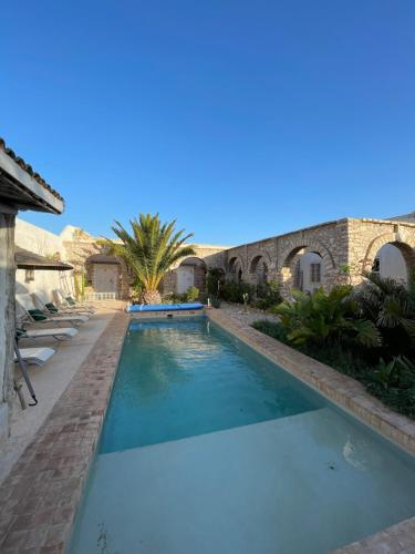 una piscina en un patio con una casa en Villa Salvatore, en Ghazoua