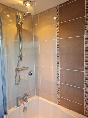 a shower with a glass door in a bathroom at Waterfall's in Borrowash