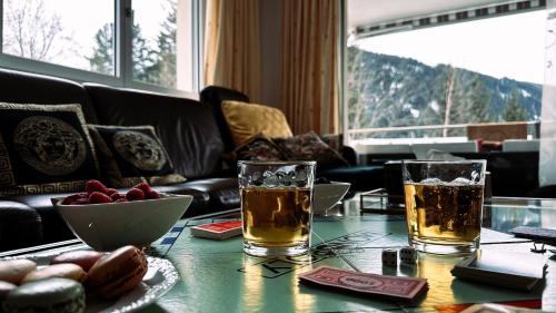 una mesa con dos copas de bebidas y un bol de fruta en Piz Alpina die grosse, moderne Wohnung mit Bergsicht en Davos