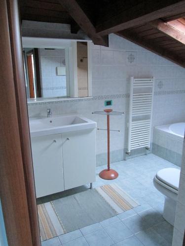 a bathroom with a sink and a toilet and a mirror at La Casa del Borgo in Brissago Valtravaglia