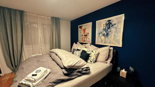 a bed in a bedroom with a blue wall at Piz Alpina die grosse, moderne Wohnung mit Bergsicht in Davos