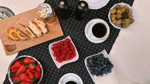 a table topped with bowls of strawberries and blueberries at Piz Alpina die grosse, moderne Wohnung mit Bergsicht in Davos