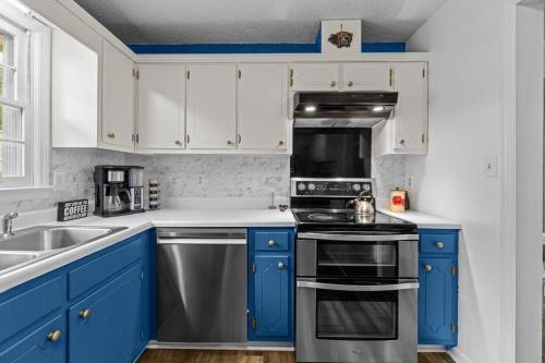 a kitchen with blue cabinets and a stove top oven at Semper Fi Serenity in Havelock