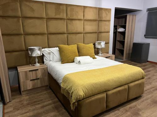 a bedroom with a large bed with a large headboard at Mulala Luxury Guesthouse in Thohoyandou