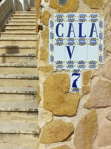 a sign on the side of a stone wall with stairs at SEA VIEW, walking distance! Refurbished 2 bed, modern. 20 min. from Alicante Airport in Santa Pola