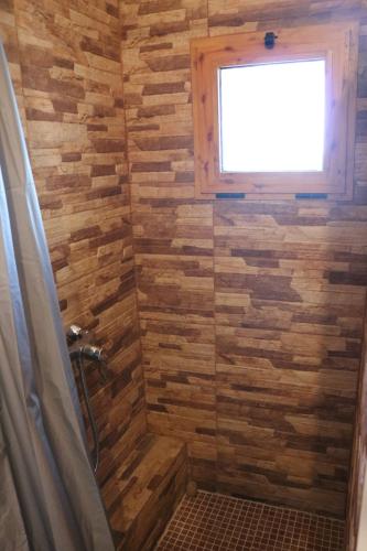 een badkamer met een douche en een houten muur bij El Regajo in Ayora
