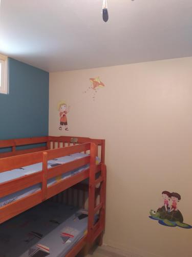 - une chambre avec des lits superposés et un cerf-volant sur le mur dans l'établissement L'Albatros, à Courseulles-sur-Mer