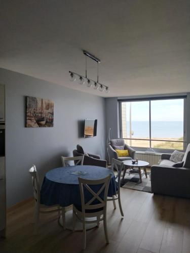 un salon avec une table et un canapé dans l'établissement L'Albatros, à Courseulles-sur-Mer