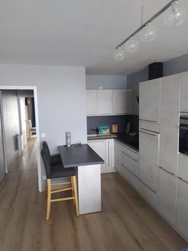 une cuisine avec des armoires blanches et un comptoir noir dans l'établissement L'Albatros, à Courseulles-sur-Mer