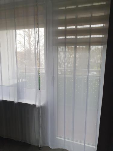 una ventana con cortinas blancas en una habitación en majvermietung, en Soest
