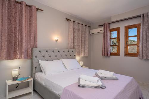 a bedroom with a white bed with two towels on it at Southbank seafront apartments in Katelios