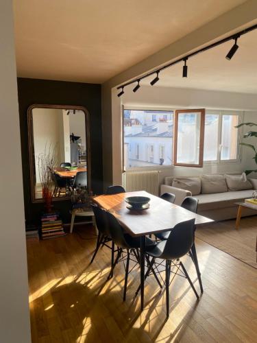 a living room with a table and chairs and a couch at Apartment in Montmartre in Paris