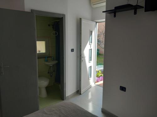 baño con aseo, lavabo y puerta en Room Ket, en Pula