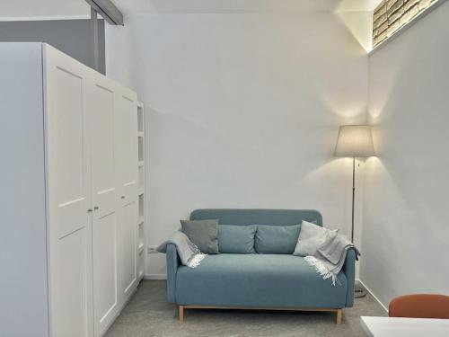 un soggiorno con divano blu e lampada di Monolatino Apartment a Roma