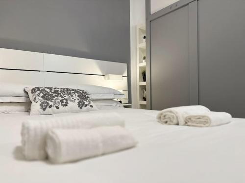 una camera da letto con due asciugamani su un letto bianco di Monolatino Apartment a Roma