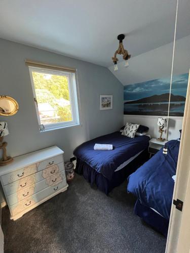 a bedroom with two beds and a window at The Mail Barn Studio in Lamlash