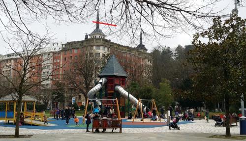 un parque infantil frente a un gran edificio en San Sebastian Centro Parking incluido, en San Sebastián