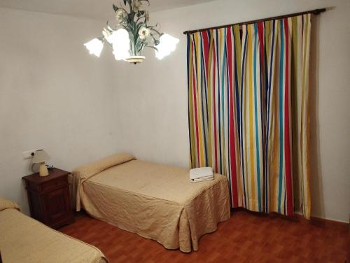 Habitación con 2 camas y cortina colorida. en La Mina de Viñon, en Viñón
