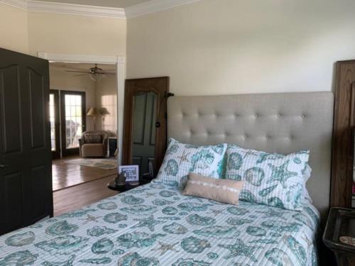 a bedroom with a large bed with blue and green pillows at At Ease in Ocean Springs