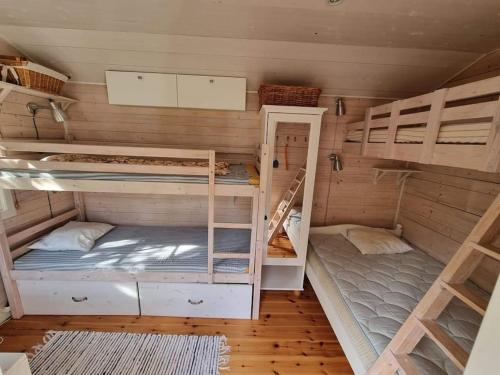 a room with two bunk beds in a house at Trevliga stugor i Torhamn, perfekt för familjer in Karlskrona