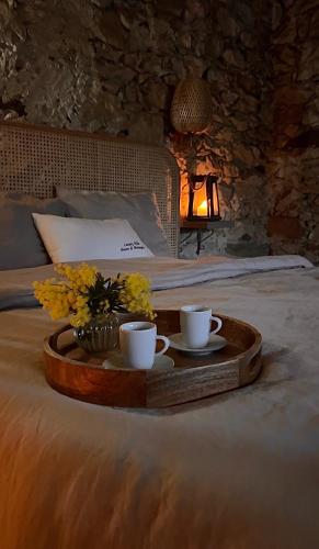 - un plateau avec 2 tasses et des fleurs sur le lit dans l'établissement Luxury Villa Amore di Montagna, à Calvo