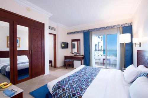 SWISS Dive Resort Hurghada في الغردقة: غرفة نوم مع سرير وإطلالة على المحيط