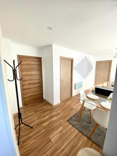 a living room with a wooden floor and a table at Apartamentos LAMAROSA -LAS PLAYAS in Burela de Cabo