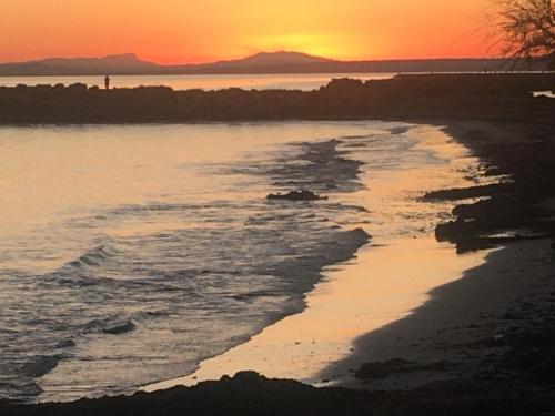 a beach with a sunset in the background at SEA VIEW, walking distance! Refurbished 2 bed, modern. 20 min. from Alicante Airport in Santa Pola