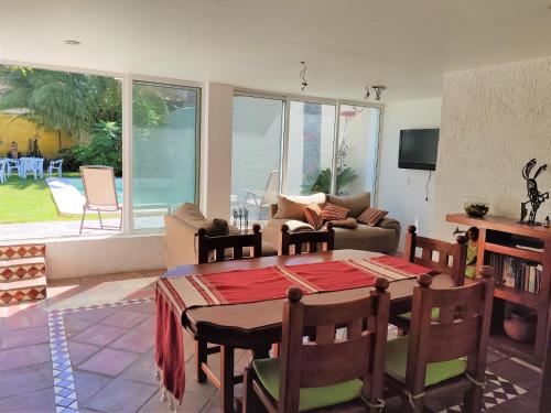 un soggiorno con tavolo, sedie e divano di Casa Jardin a Guadalajara
