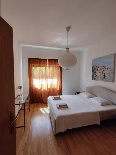 a bedroom with a large white bed and a window at Spacious garden house, Orebić (4+1) in Orebić