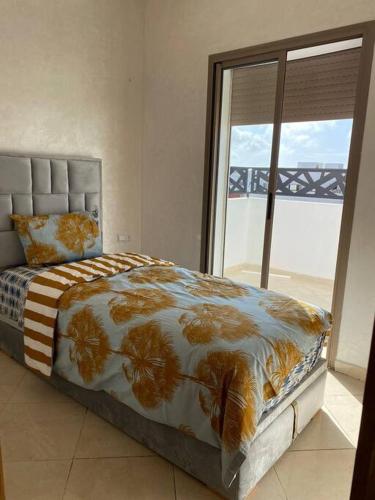a bedroom with a bed and a large window at Panoramique appartement in Kenitra